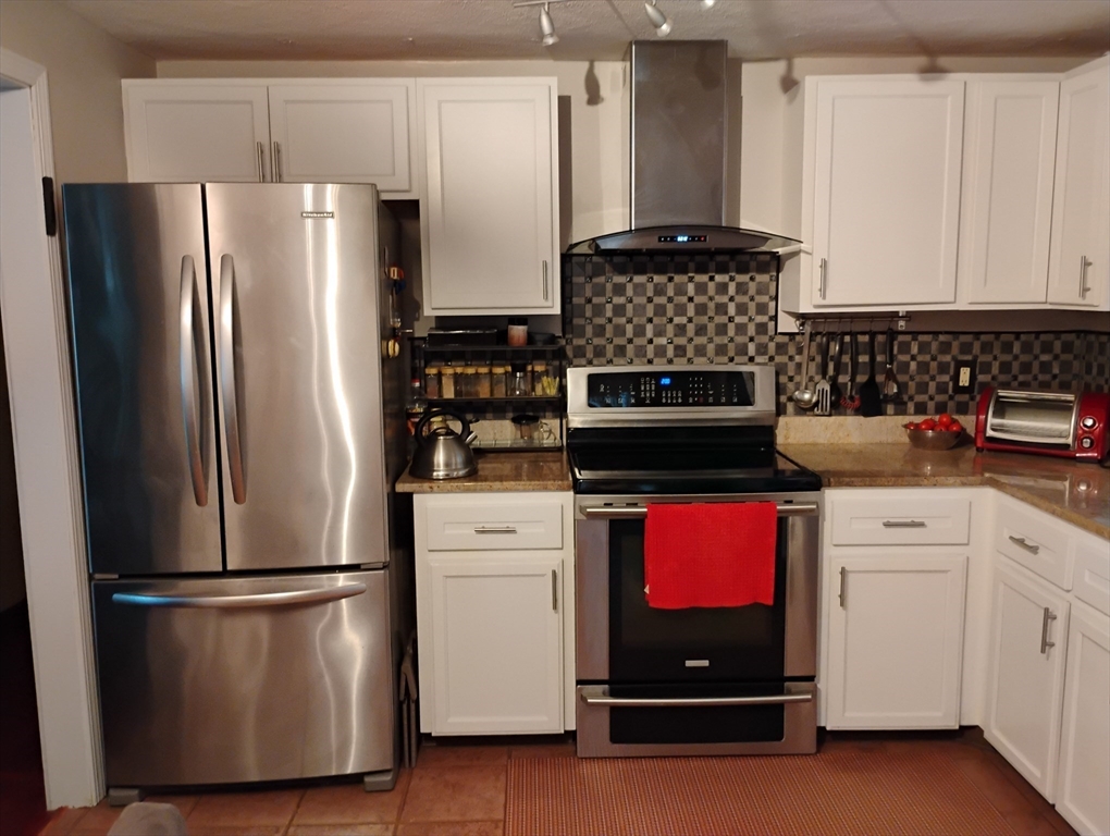 9 Packard Road Milford, MA 01757 - Photo 5 of 30 a kitchen with refrigerator and stove
