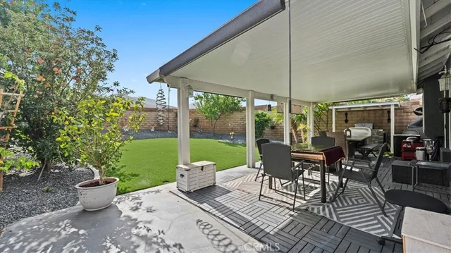 a view of a patio with table and chairs and potted plants