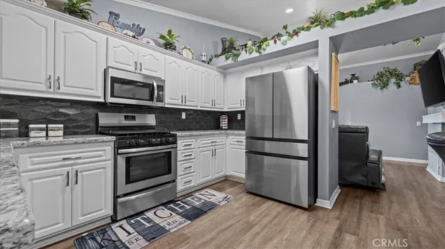 a kitchen with stainless steel appliances granite countertop a refrigerator stove and sink