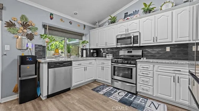 a kitchen with stainless steel appliances granite countertop a stove a sink and a microwave