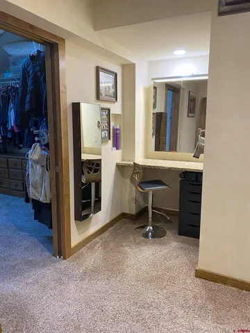 a view of a workspace with furniture and a window