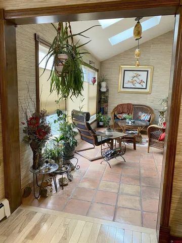 a living room with furniture and potted plants