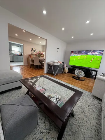 a living room with furniture pool table and a flat screen tv