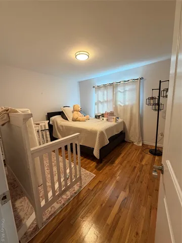 a bedroom with two beds and wooden floor