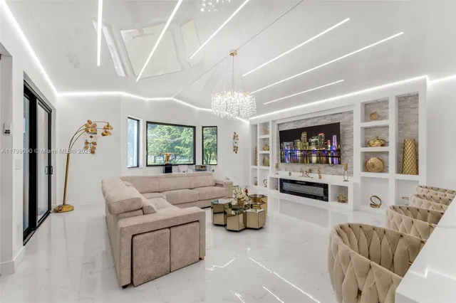 a living room with furniture kitchen view and a chandelier