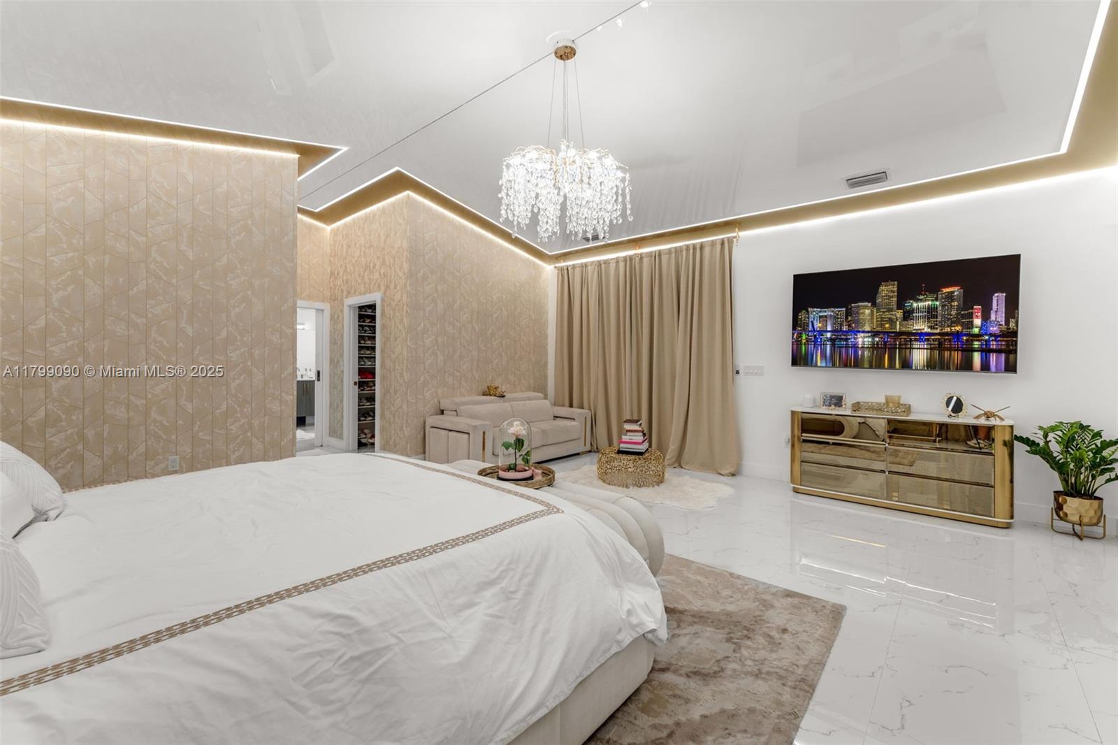 17795 Southwest 158th Street Miami, FL 33187 - Photo 19 of 45 a spacious bedroom with a bed a chandelier and a large mirror on the dresser