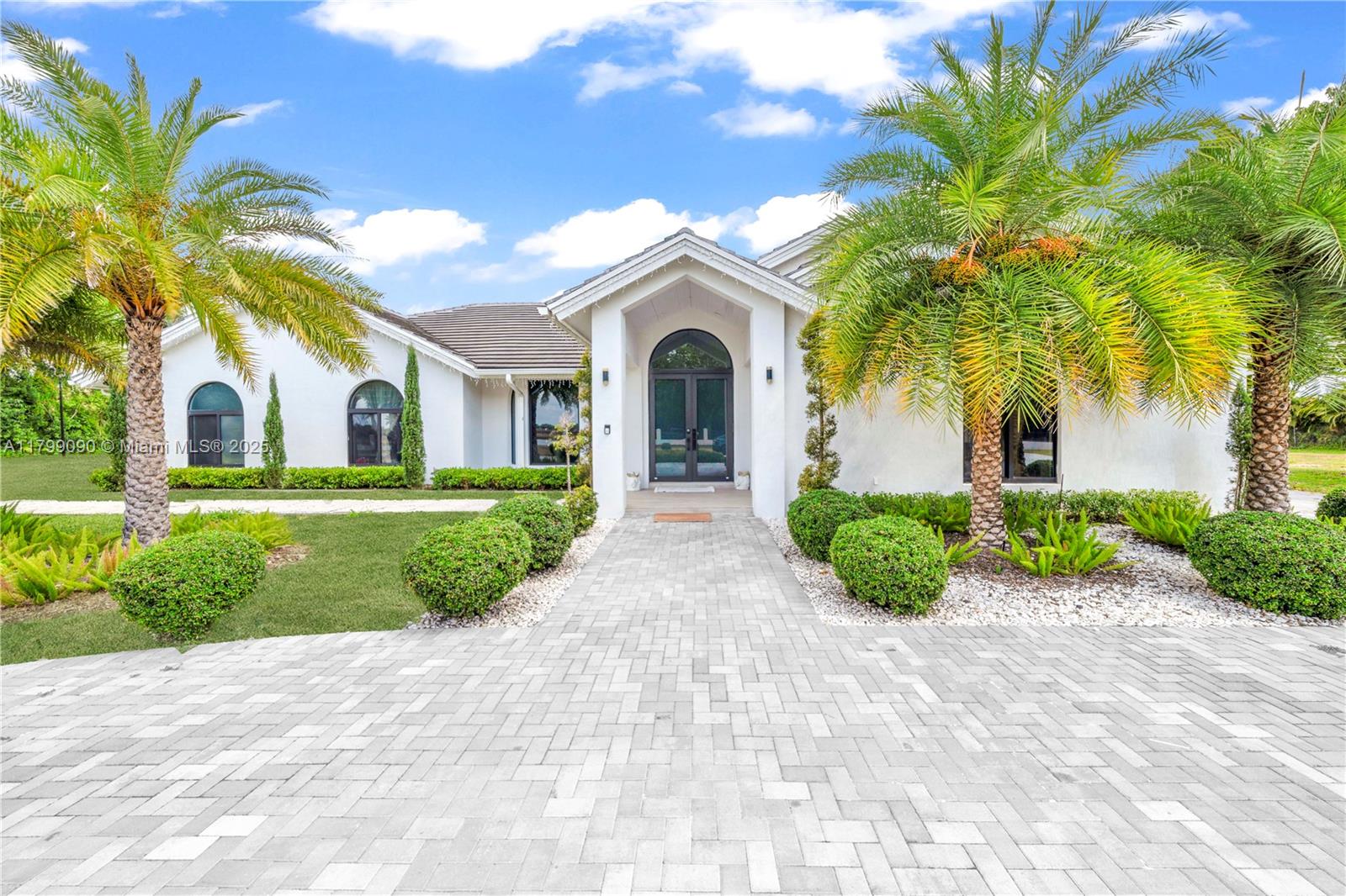 17795 Southwest 158th Street Miami, FL 33187 - Photo 2 of 45 a front view of a house with a garden and plants