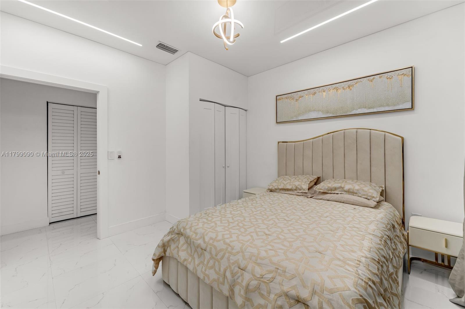 17795 Southwest 158th Street Miami, FL 33187 - Photo 31 of 45 a bedroom with a bed and a chandelier