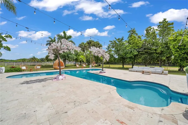 a view of house with swimming pool outdoor seating