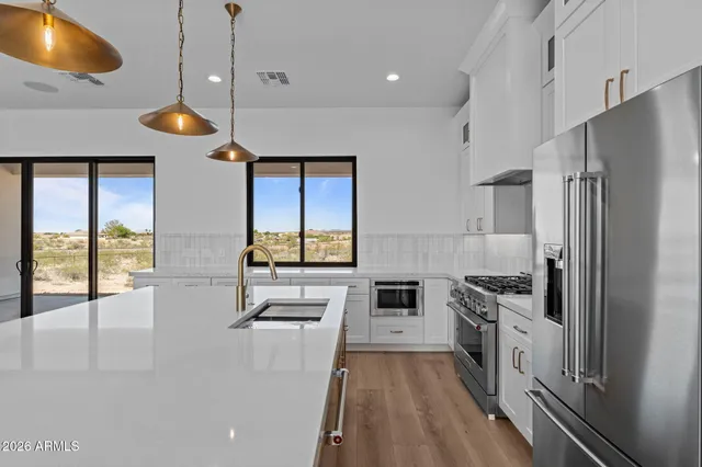 a kitchen with stainless steel appliances granite countertop a sink a stove and a refrigerator