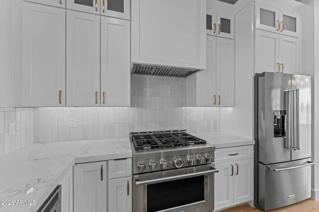 a kitchen with stainless steel appliances granite countertop a stove refrigerator and a stove