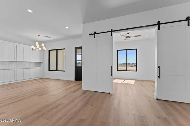 a view of empty room with kitchen appliances and wooden floor