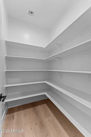 a kitchen with stainless steel appliances a white cabinets and wooden floor