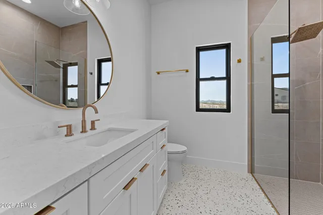 a bathroom with a sink a toilet and shower