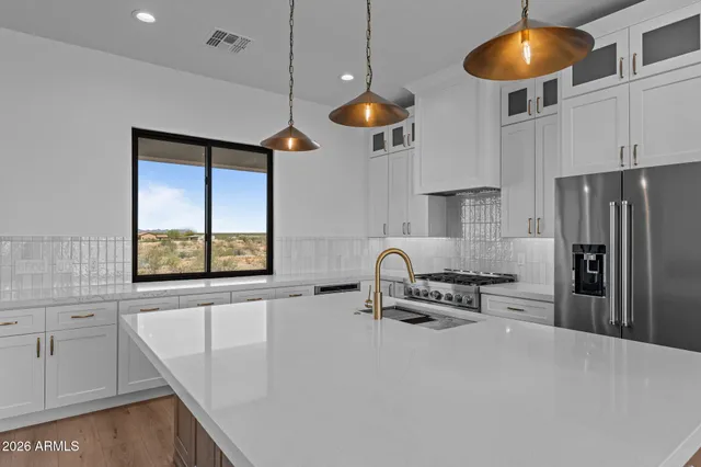 a kitchen with stainless steel appliances granite countertop a sink a oven and a view of living room