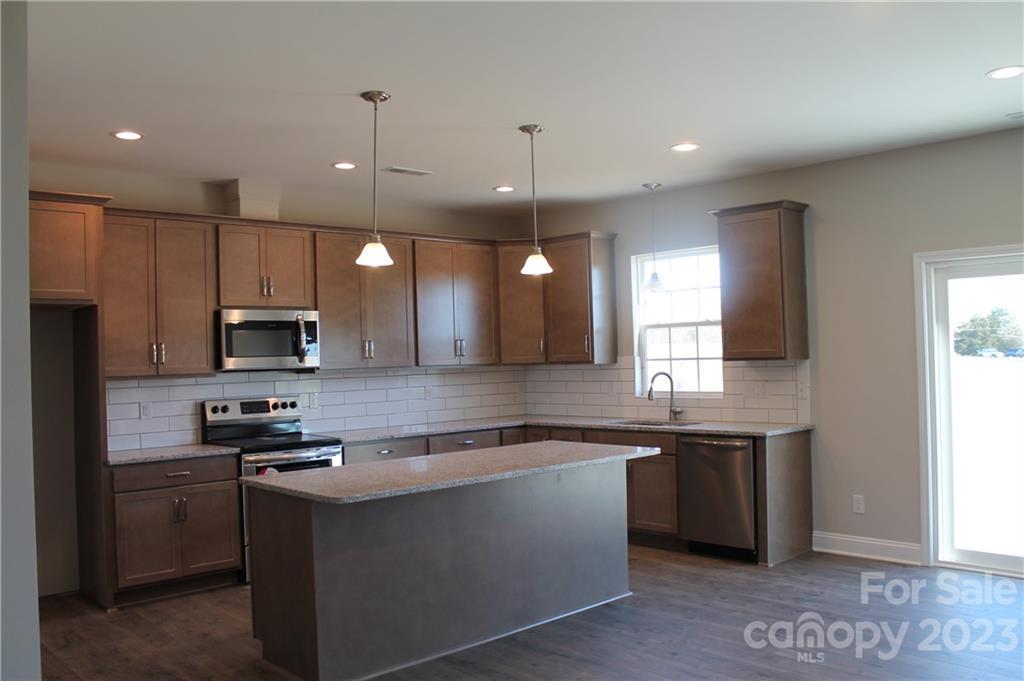 3224 Austin Chaney Road Monroe, NC 28110 - Photo 3 of 23 a kitchen with stainless steel appliances granite countertop a sink a stove a refrigerator and a microwave