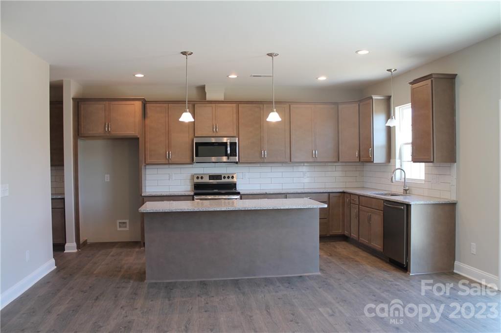 3224 Austin Chaney Road Monroe, NC 28110 - Photo 5 of 23 a large kitchen with stainless steel appliances kitchen island a large counter top and wooden floors