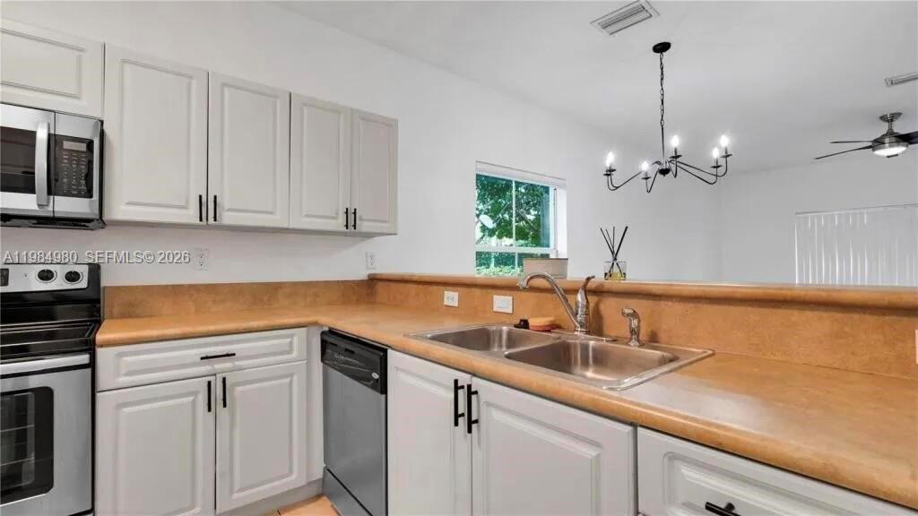 4921 Southwest 140th Terrace, Unit 1 Miramar, FL 33027 - Photo 4 of 16 a kitchen with sink cabinets and stainless steel appliances