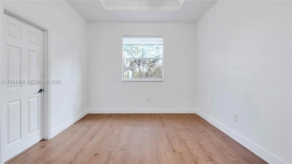 4921 Southwest 140th Terrace, Unit 1 Miramar, FL 33027 - Photo 9 of 16 an empty room with wooden floor and windows