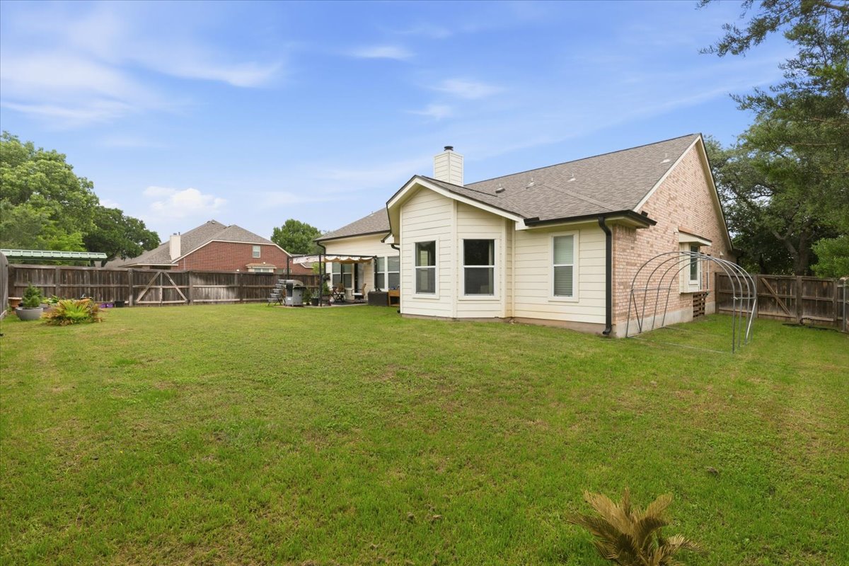 2501 Aspen Meadow Road Leander, TX 78641 - Photo 29 of 30 Spacious fenced backyard featuring a grassy lawn and a brick and siding exterior