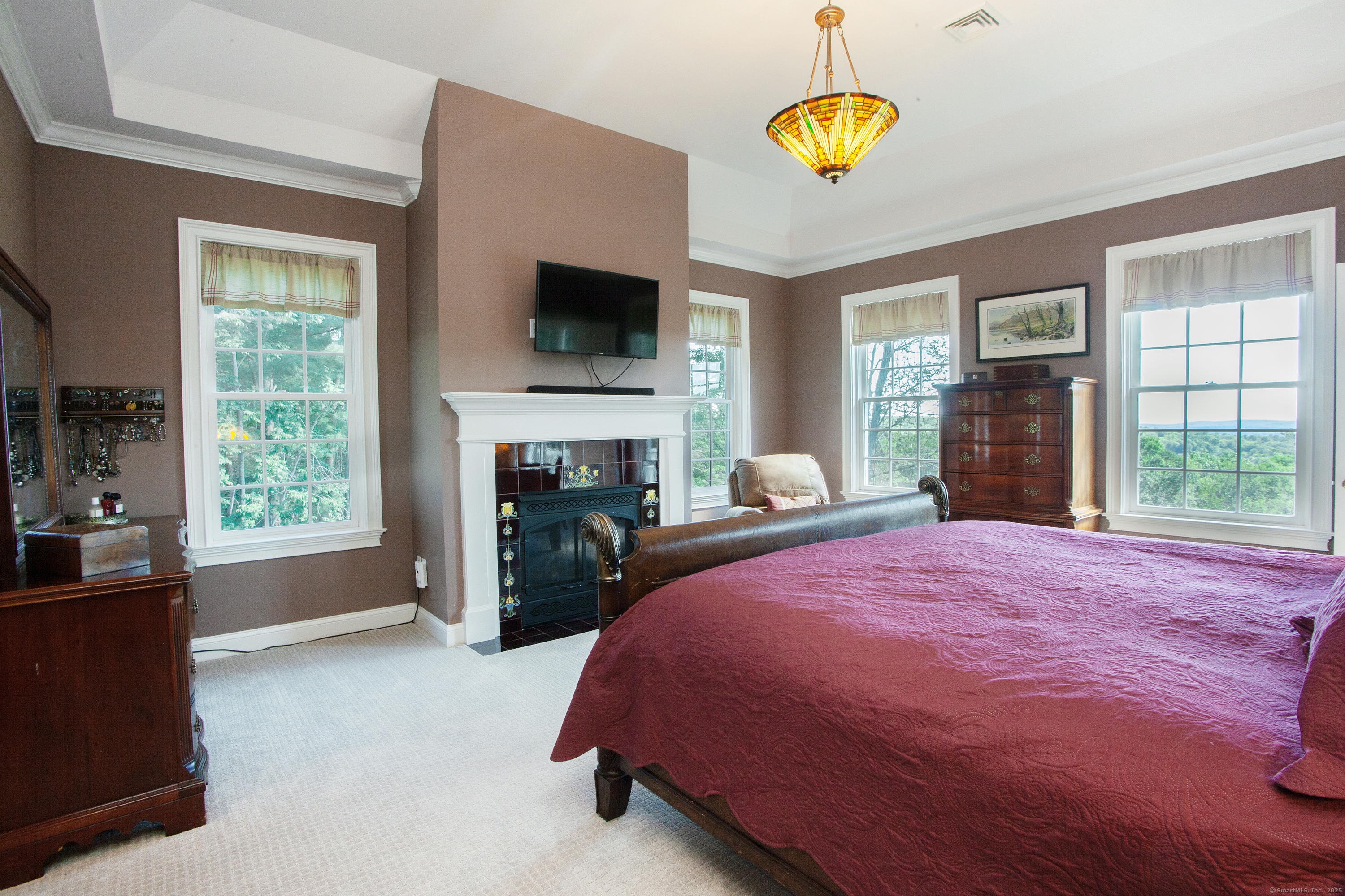 15 Old Orchard Road Granby, CT 06090 - Photo 17 of 32 The primary bedroom features a gas fireplace with a tubeline tile surround.