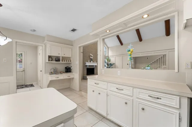 a kitchen with white cabinets and appliances