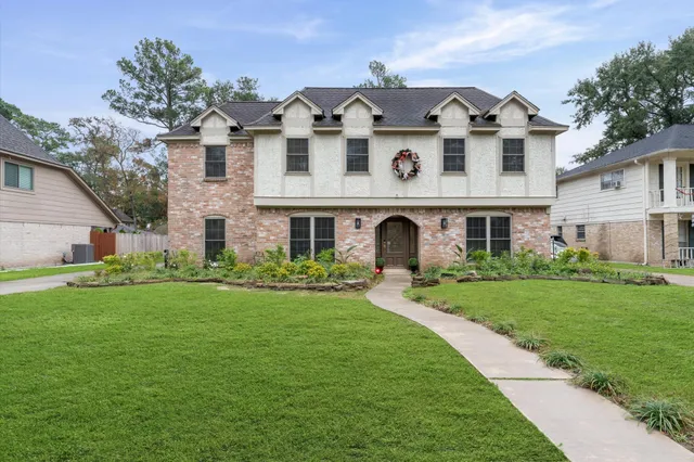 a view of a house with a backyard and a tree