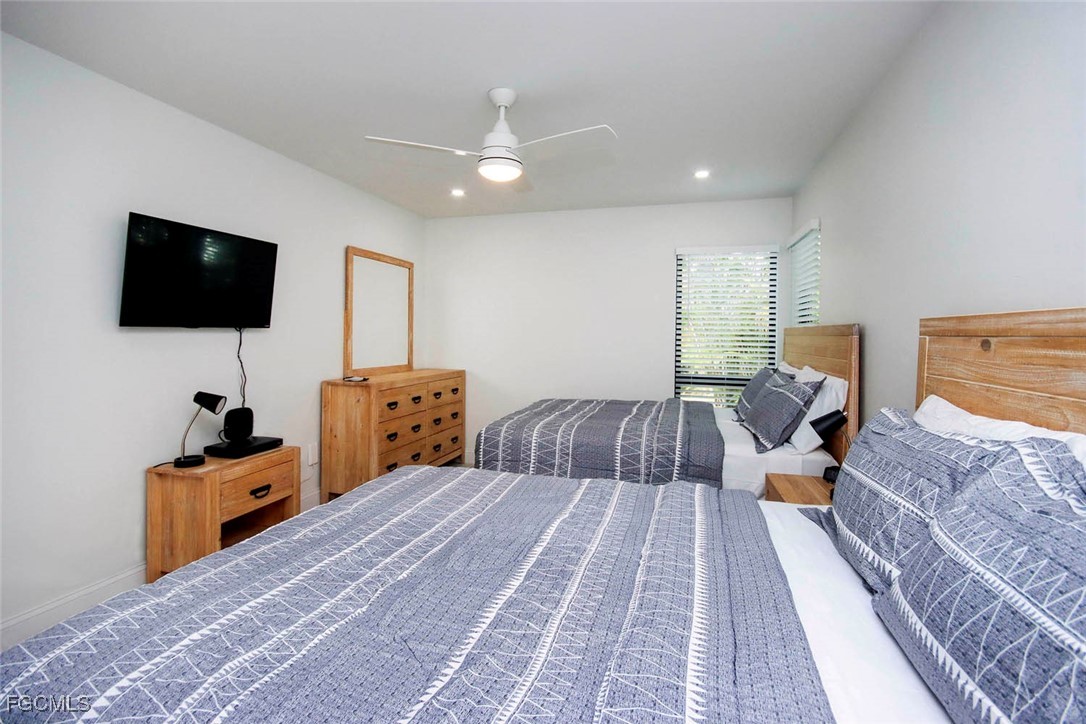 5117 Sea Bell Road, Unit A102 Sanibel, FL 33957 - Photo 16 of 21 a bedroom with a bed and a flat screen tv