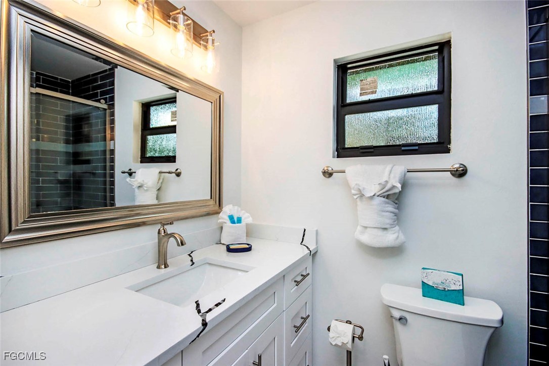 5117 Sea Bell Road, Unit A102 Sanibel, FL 33957 - Photo 17 of 21 a bathroom with a toilet sink and mirror