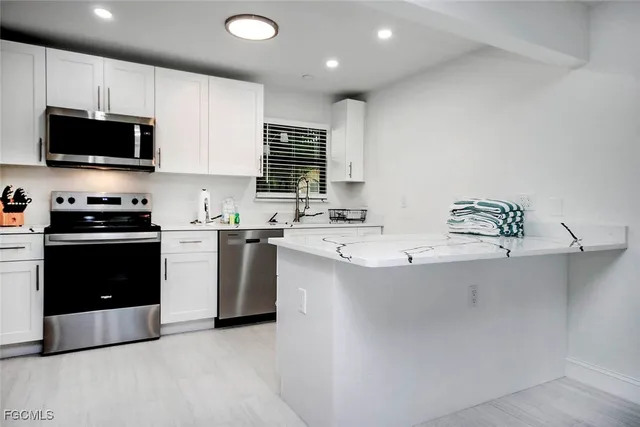 a kitchen with stainless steel appliances a stove a sink a microwave and cabinets