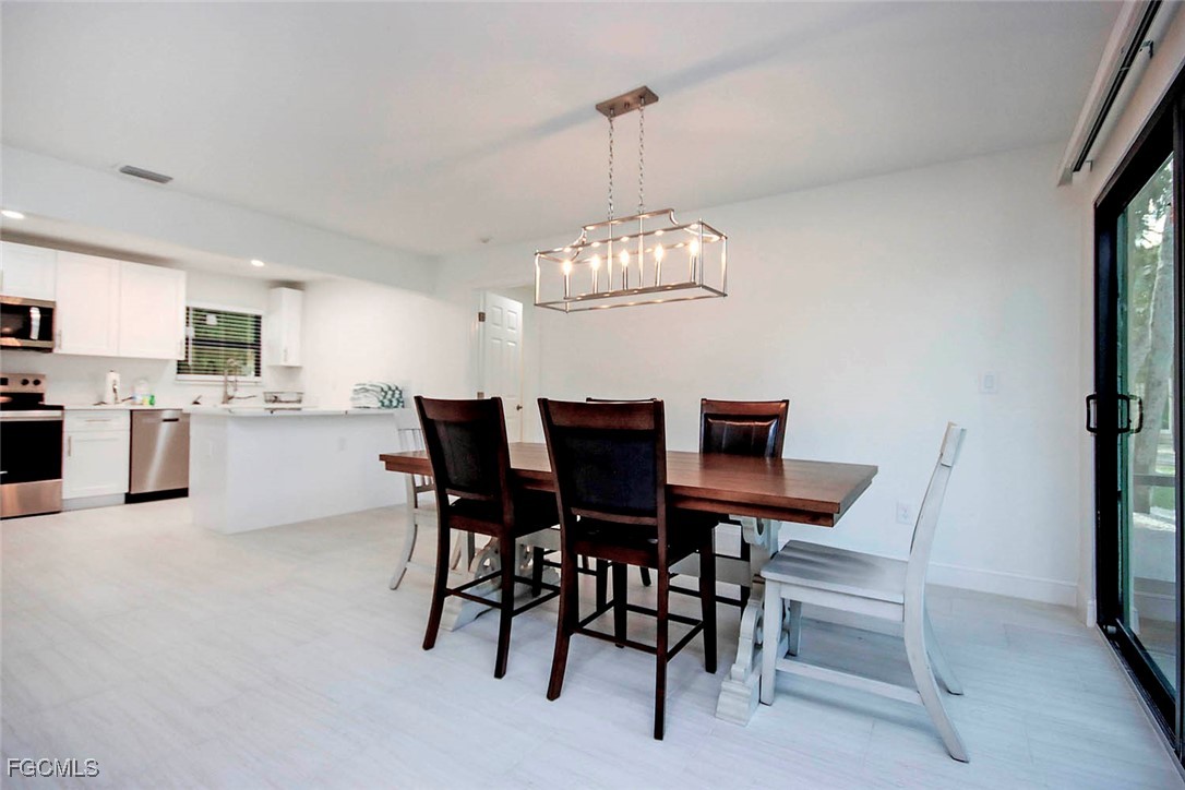 5117 Sea Bell Road, Unit A102 Sanibel, FL 33957 - Photo 9 of 21 a view of a dining room with furniture and chandelier
