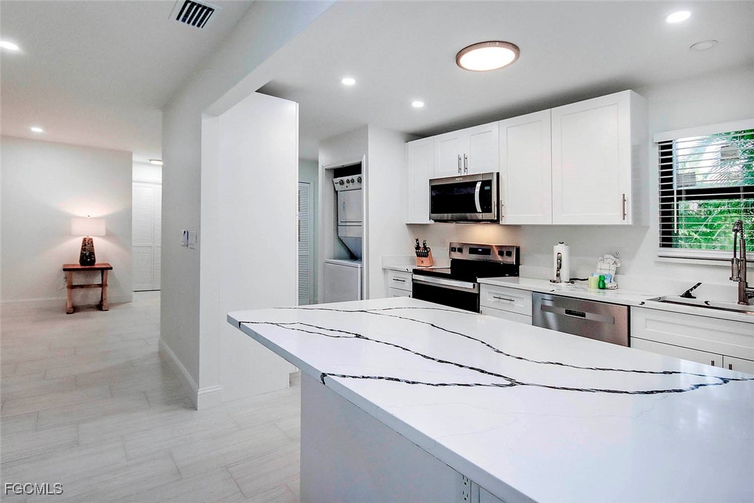 5117 Sea Bell Road, Unit A102 Sanibel, FL 33957 - Photo 10 of 21 a kitchen with granite countertop a refrigerator stove top oven and sink