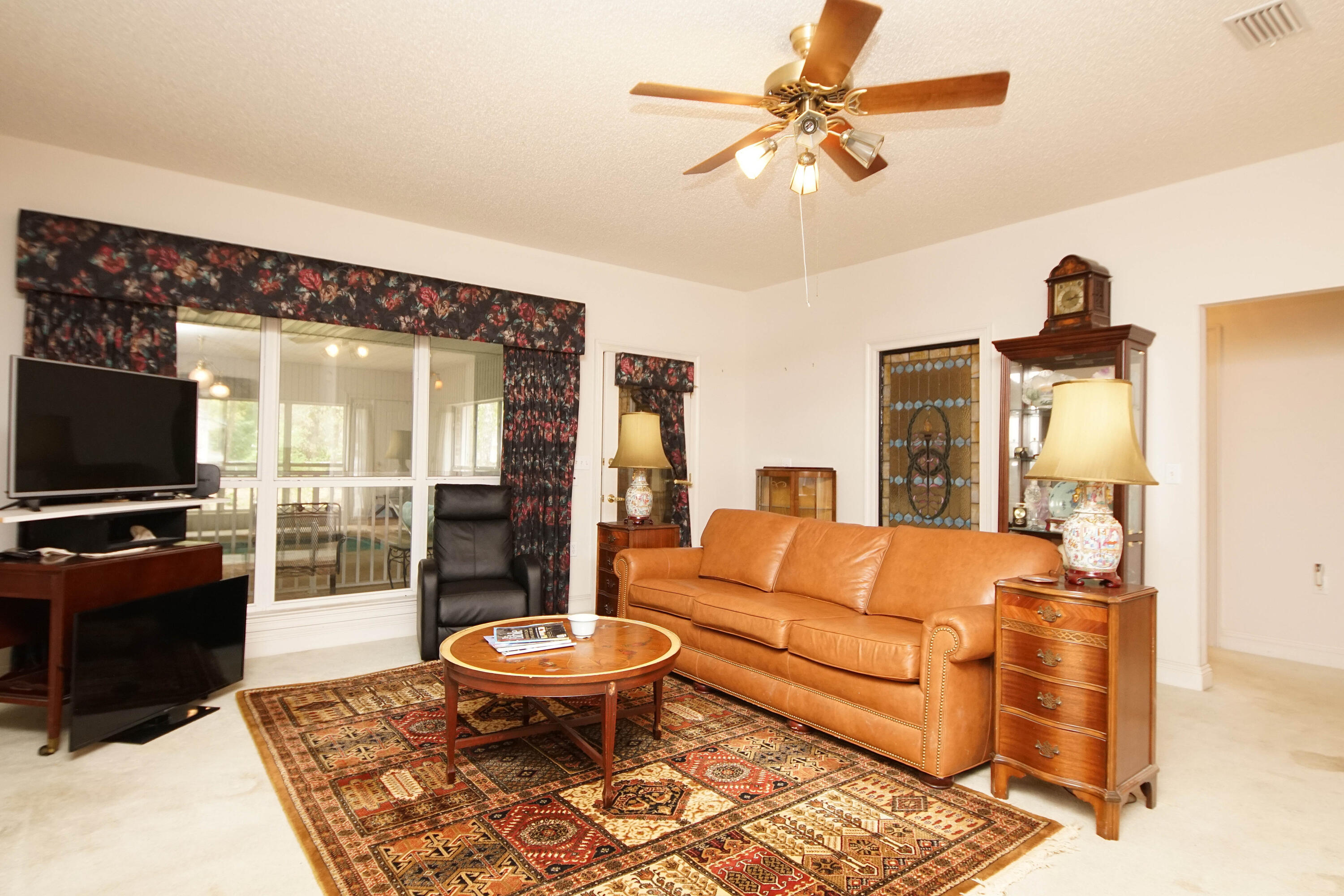 600 Northwest Mooney Road Fort Walton Beach, FL 32547 - Photo 13 of 35 a living room with furniture a flat screen tv and a large window
