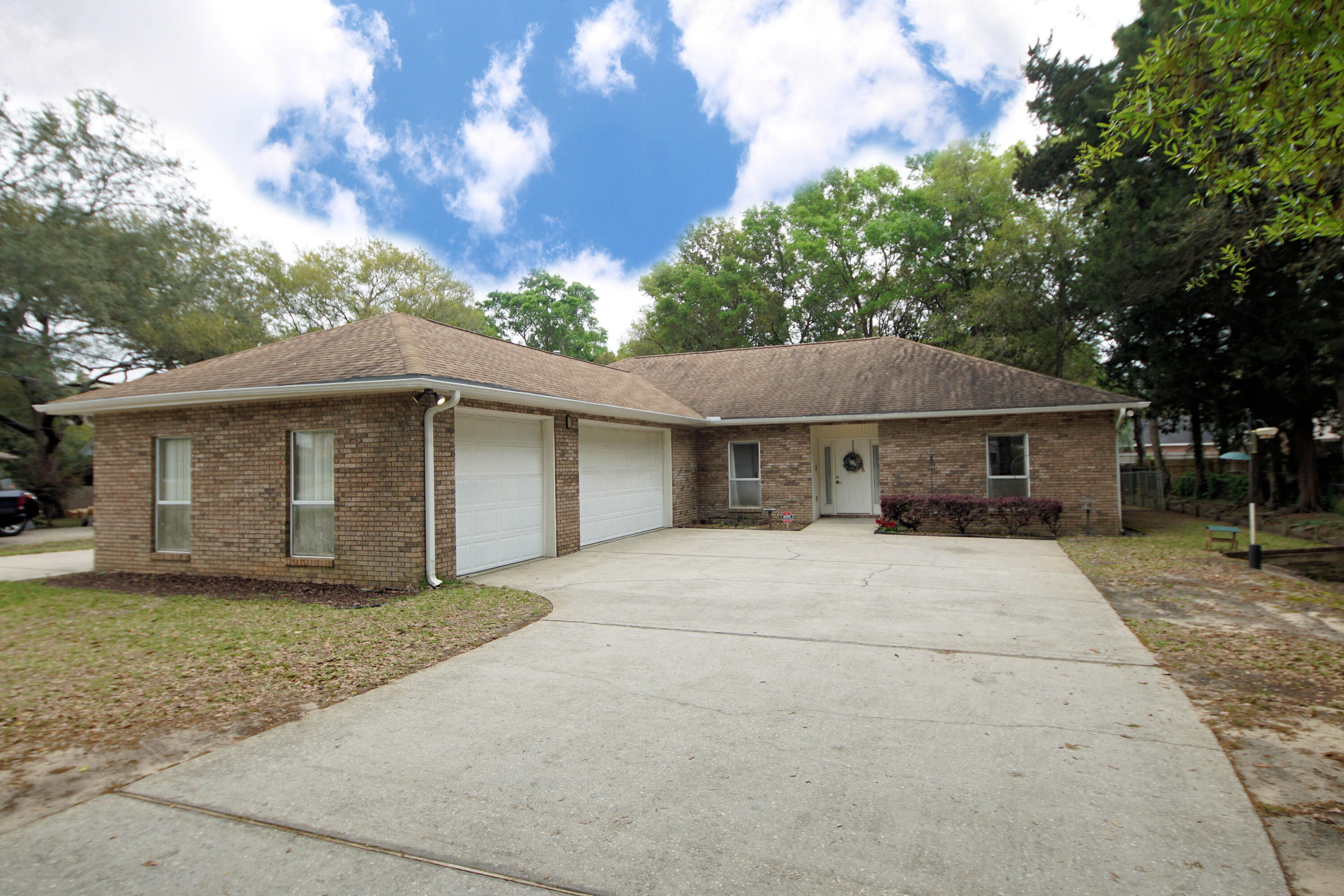 600 Northwest Mooney Road Fort Walton Beach, FL 32547 - Photo 2 of 35 a front view of a house with a garden and trees