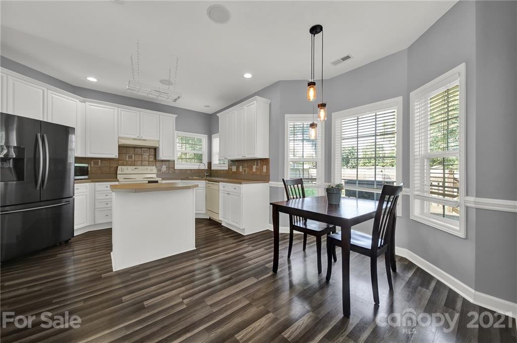 3307 Creek Trail Road Indian Trail, NC 28079 - Photo 10 of 43 a kitchen with stainless steel appliances granite countertop a stove a refrigerator a kitchen island a dining table and chairs