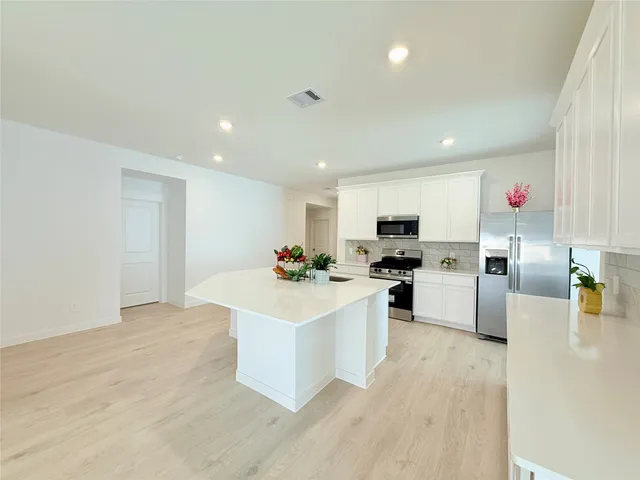 a kitchen with a sink stainless steel appliances and white cabinets