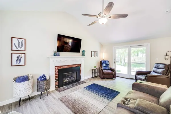 a living room with furniture a fireplace and a flat screen tv