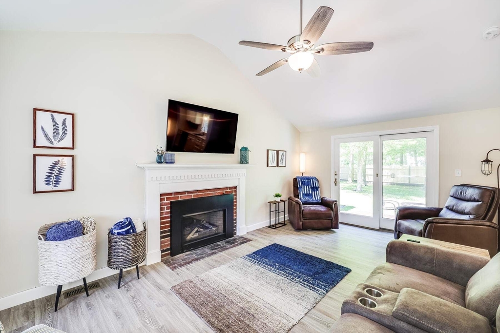36 Sylvia Lane, Unit 36 Barnstable, MA 02632 - Photo 2 of 9 a living room with furniture a fireplace and a flat screen tv