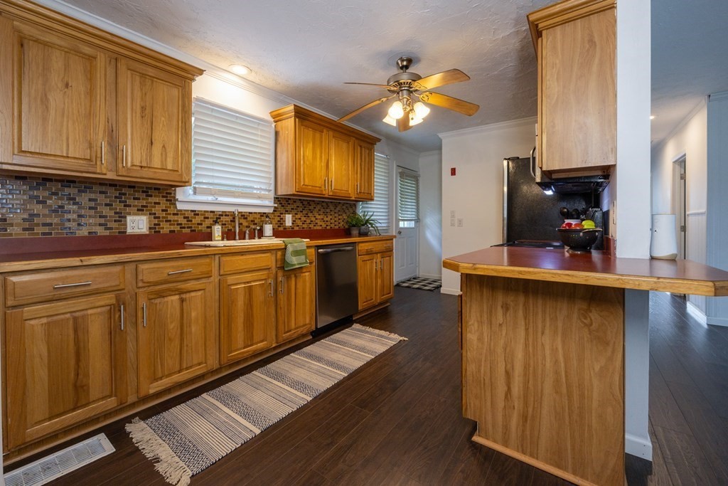 38 Ridge Street Westminster, MA 01473 - Photo 4 of 27 a kitchen with stainless steel appliances granite countertop wooden cabinets a stove top oven a sink and dishwasher with wooden floor