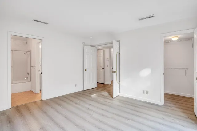 a spacious bathroom with a granite countertop sink a toilet a mirror and shower
