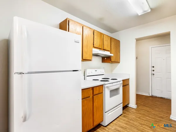 a kitchen with a stove a refrigerator and a window