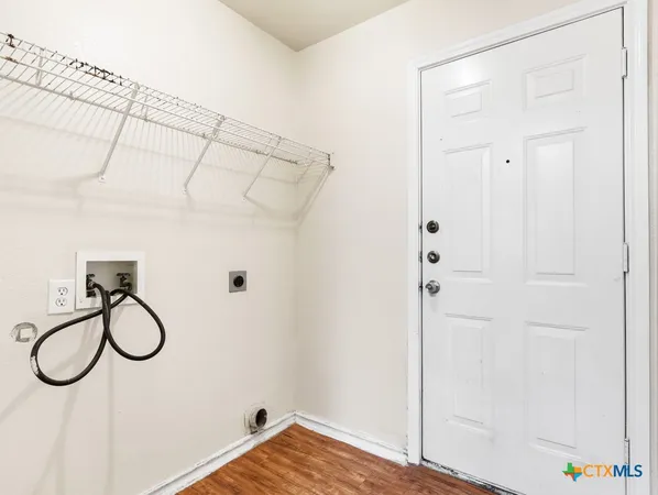 a view of a closet with wooden floor