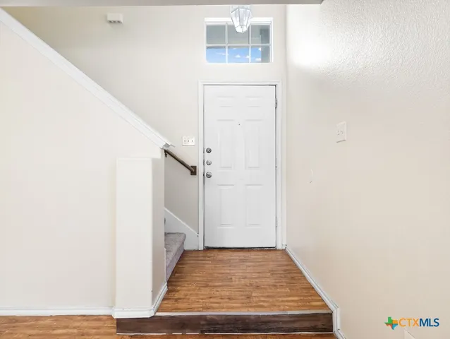 a view of a livingroom with wooden floor and entryway