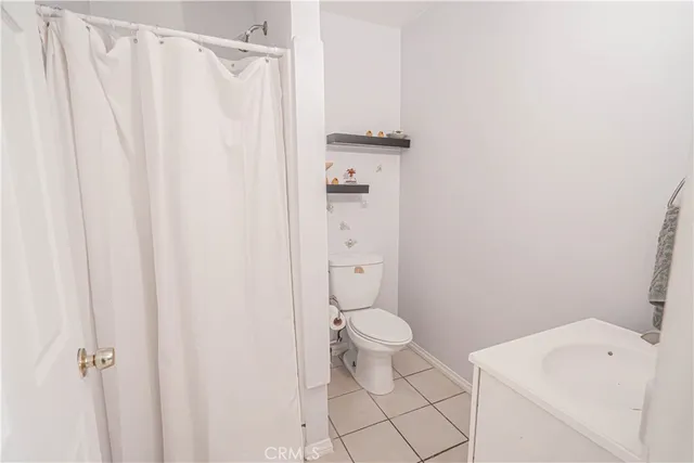 a bathroom with a sink a toilet and a shower curtain
