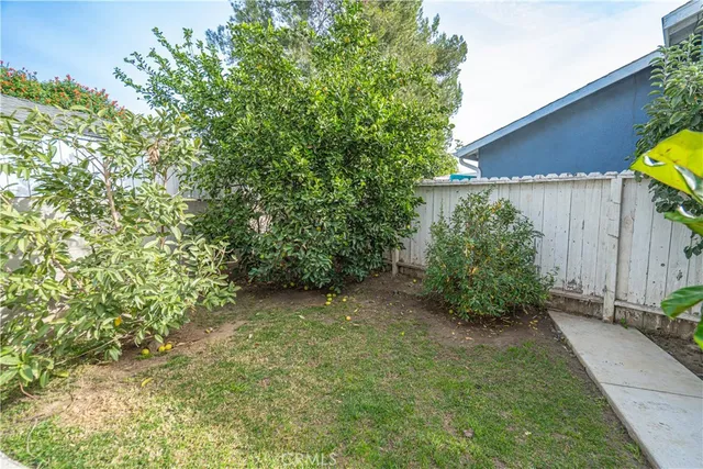 a backyard of a house with plants and outdoor seating