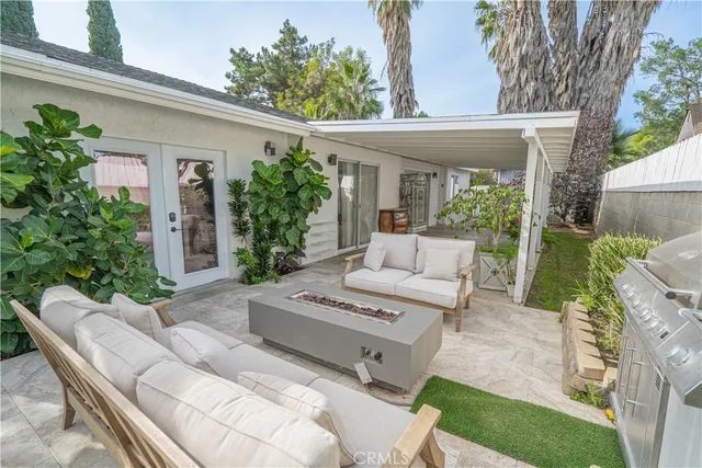 a view of a patio with couches table and chairs and potted plants