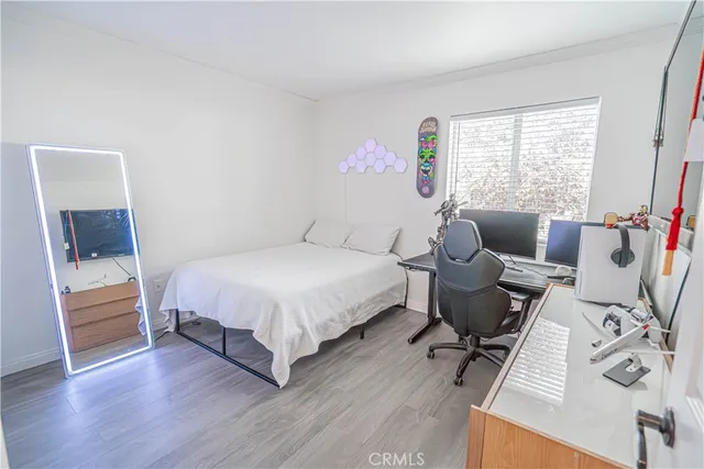 a spacious bedroom with a bed and wooden floor