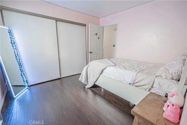 a bedroom with a bed and wooden floor