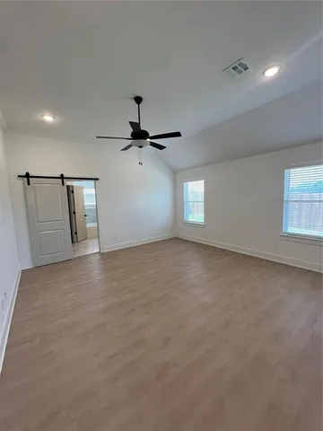 an empty room with windows and fan