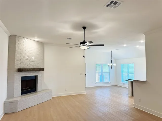 an empty room with a fireplace and wooden floor